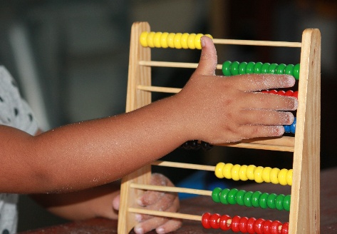 Kinderhand op een kleurrijk telraam