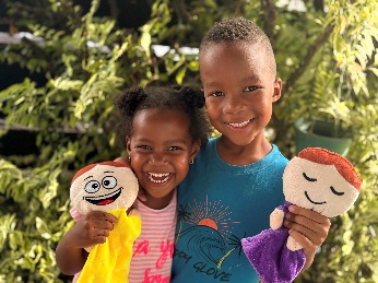 Twee lachende kinderen met gevoelenshandpoppen